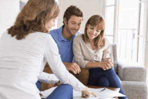 Couple reviewing paperwork with a professional before house hunting