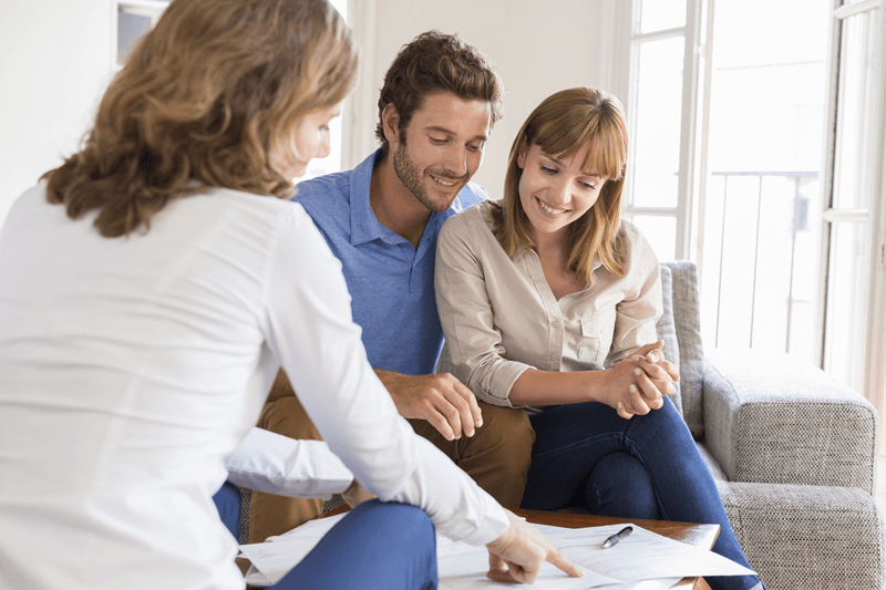 Couple reviewing paperwork with a professional before house hunting