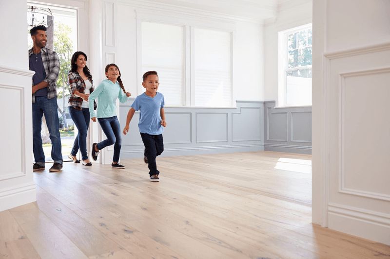 Family of four excitedly walking into a new home using a VA loan